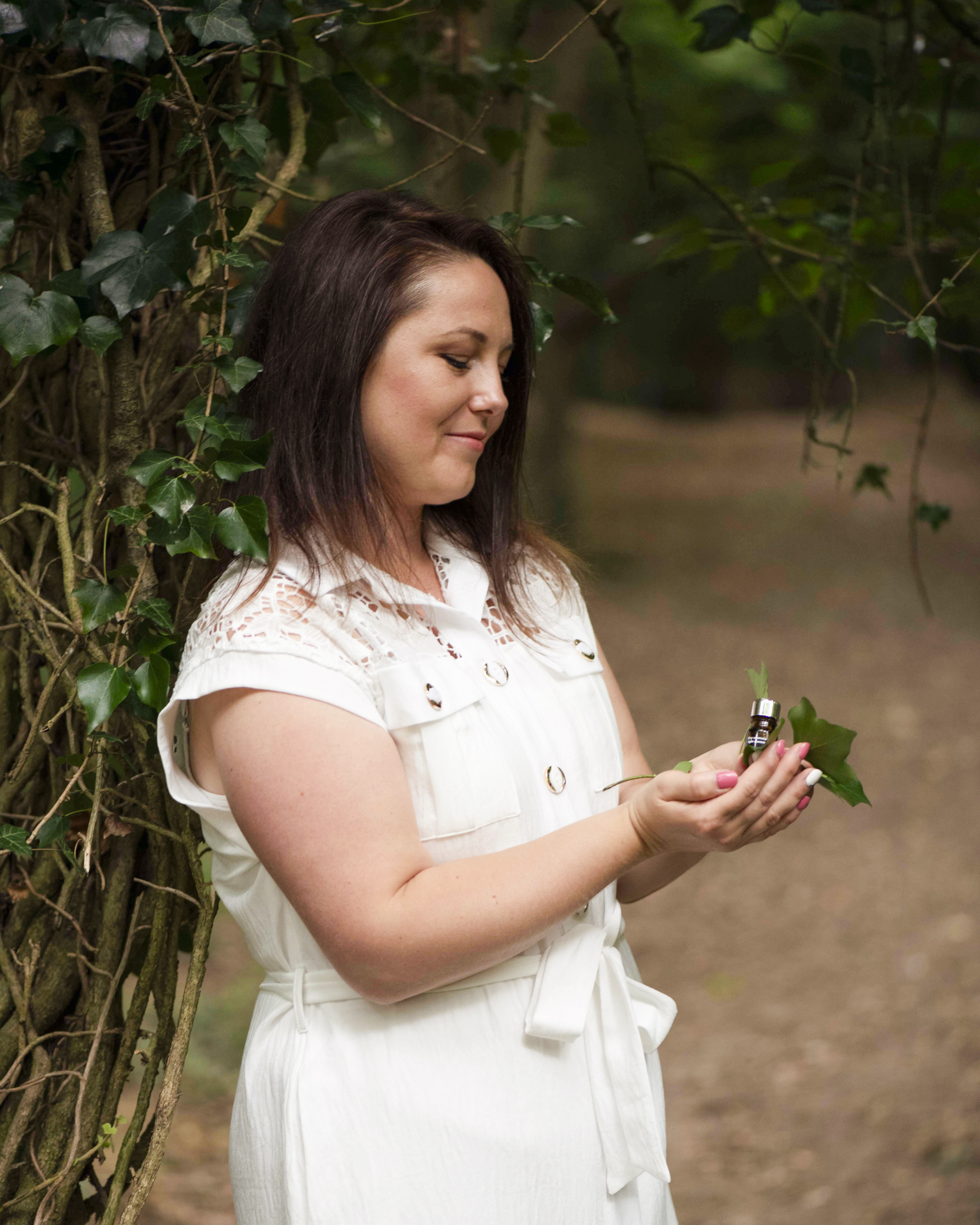 Judit holding a small bottle and leaves in nature